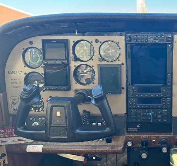 The cockpit instrument panel of an aircraft, showing various gauges and modern avionics.