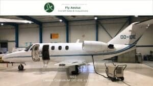 Side view of the Cessna CitationJet OO-IDE in a hangar with the door open.