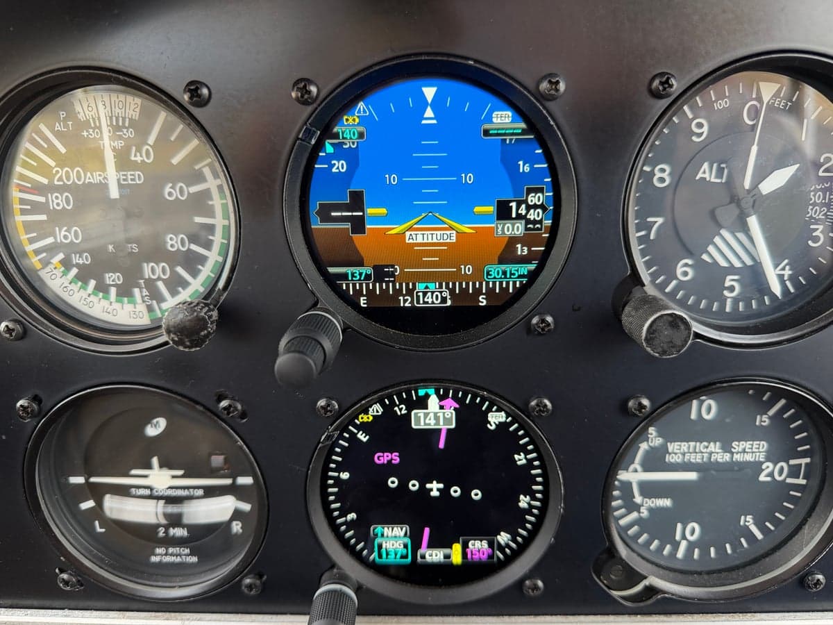 Close-up of the attitude indicator and other instruments in the cockpit.