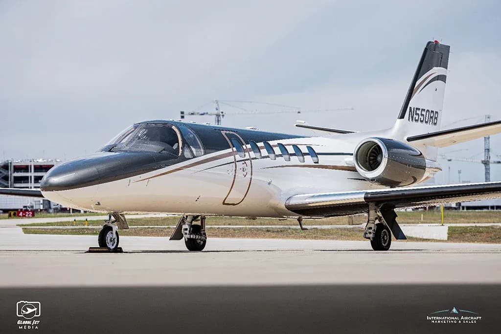 A close-up view of the front-right side of a white and dark grey Cessna Citation V (N550RB) business jet on a tarmac.