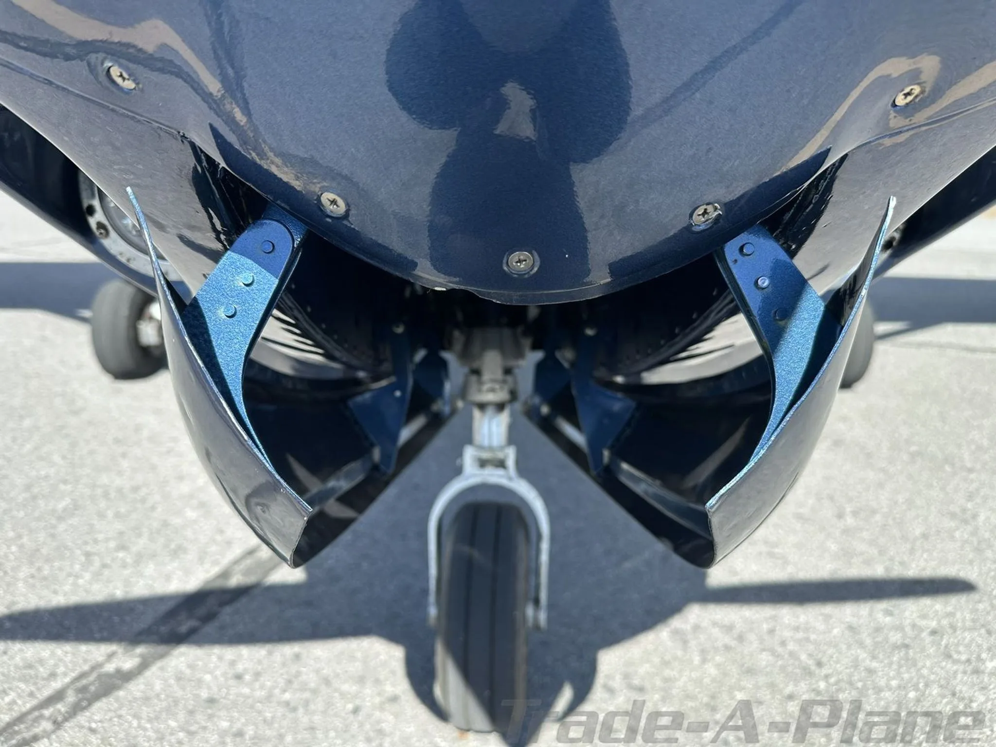 Close-up view of the dark blue nose gear and engine cowling of the N108EA aircraft.
