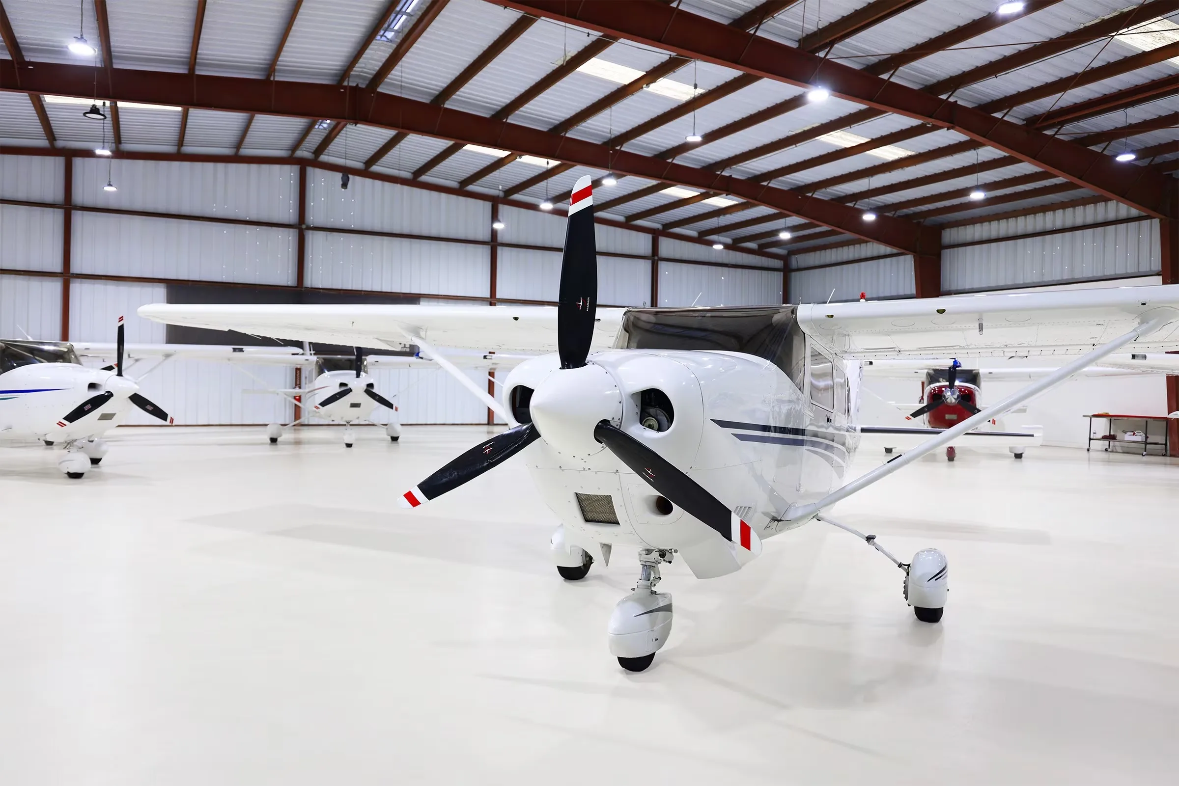 A front view of a white Cessna Stationair TC aircraft (N72638) with a black propeller in a hangar.