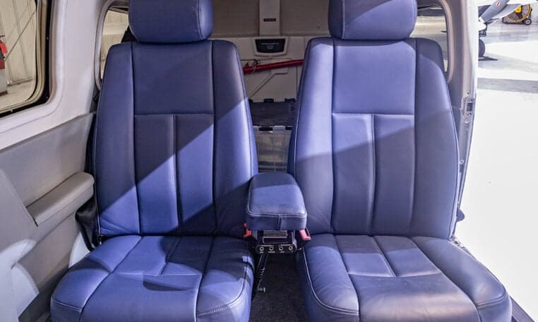 Close-up of the blue leather seats in the aircraft cabin.