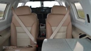 View of the aircraft's interior with seats and seatbelts.