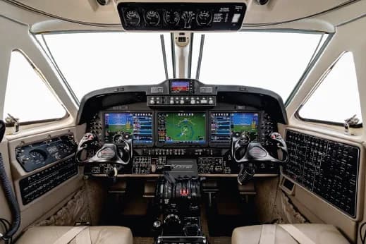 The cockpit of a King Air 360, featuring a modern glass panel display and dual yokes.
