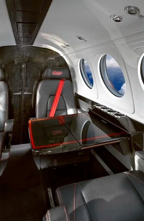 The interior of a King Air aircraft with leather seats and a table.