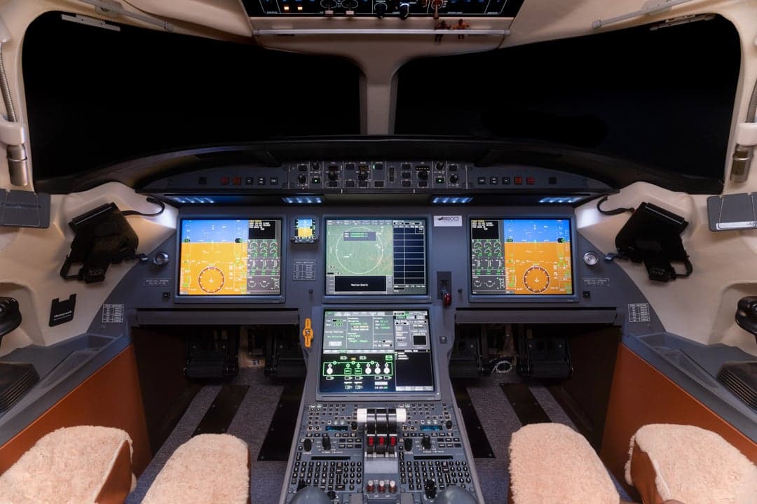 View of the aircraft cockpit with multiple display screens.