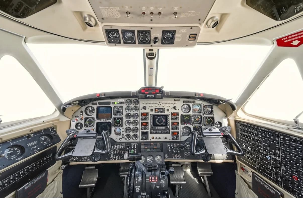 The aircraft's cockpit displays a comprehensive instrument panel with various gauges, screens, and control yokes.