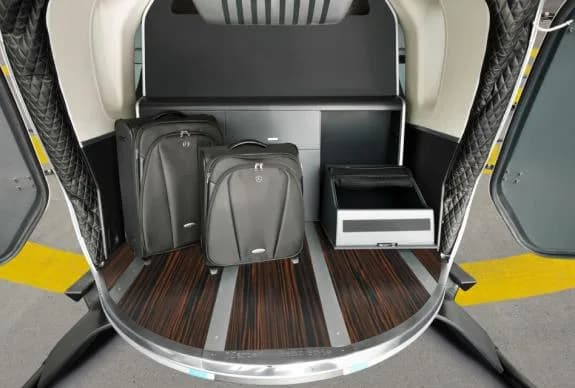 Rear luggage compartment of the helicopter with two black suitcases.