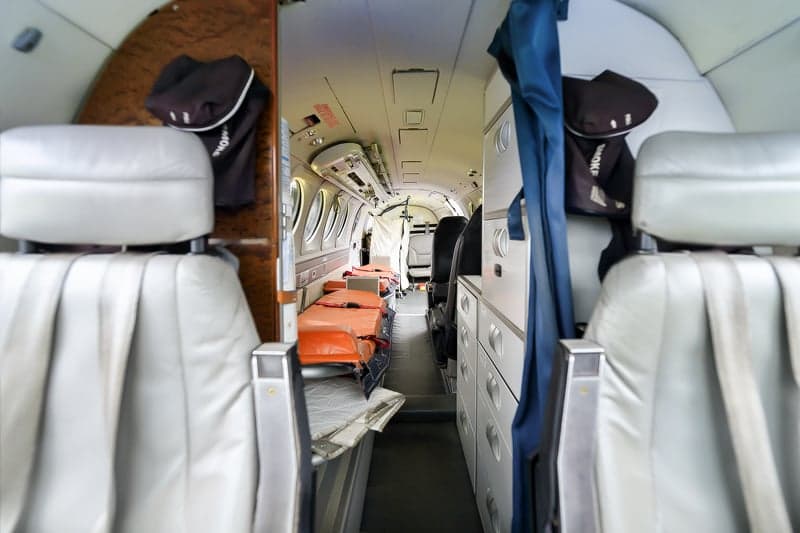 View down the aisle of the aircraft's interior, showing seats and stretchers.