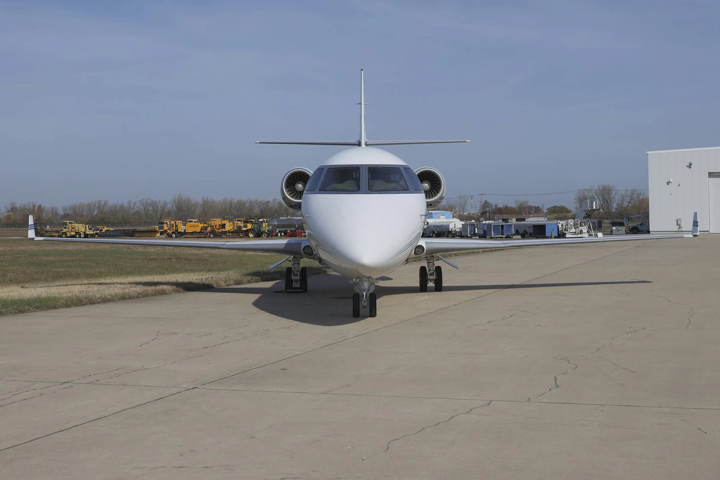 Front view of a white Gulfstream jet on the tarmac.