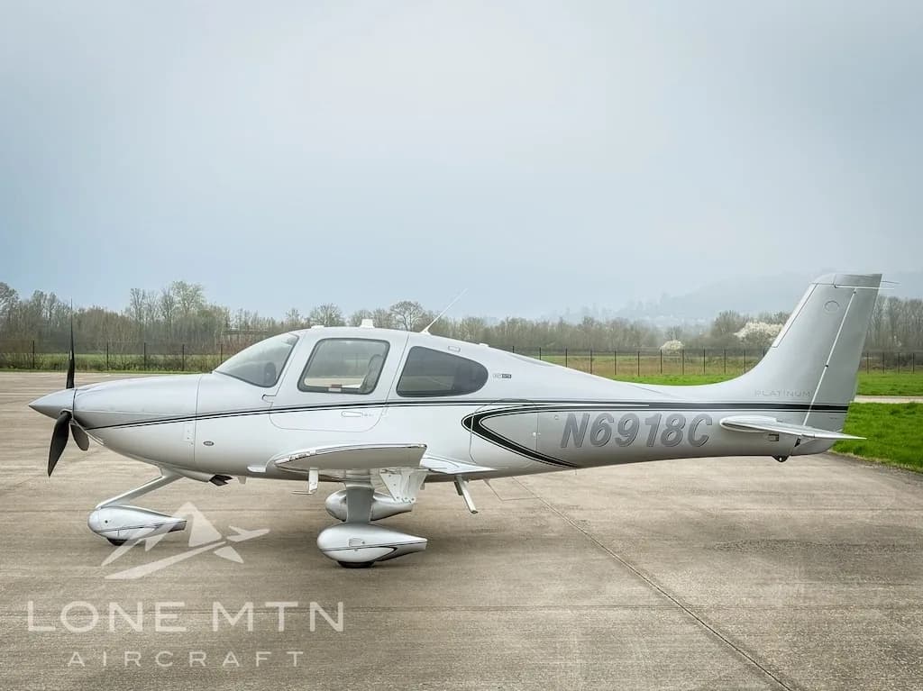 Side view of a silver Cirrus SR22 aircraft, registration N6918C, parked on an airfield.