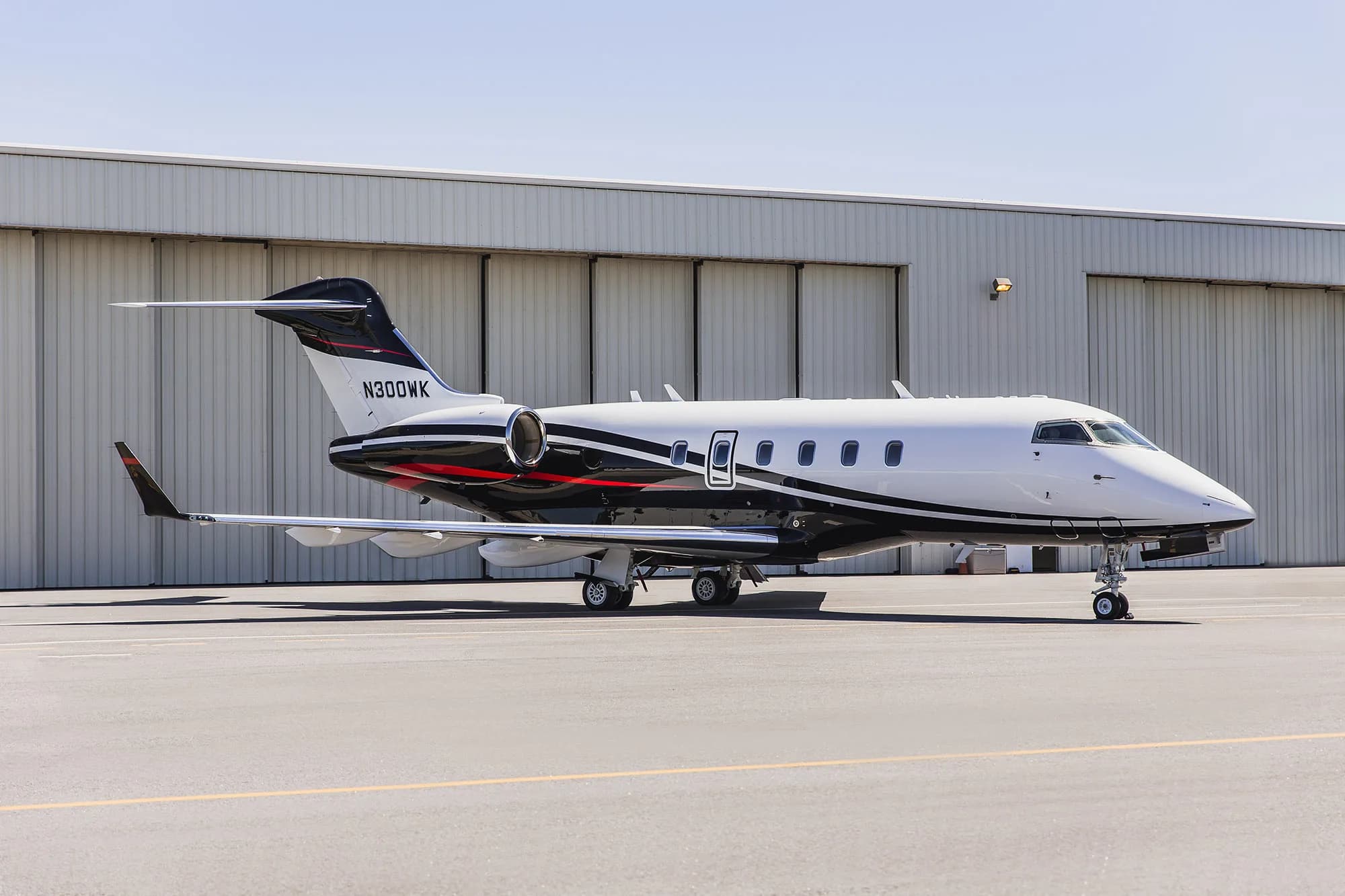 Side view of the N300WK aircraft parked on the tarmac.