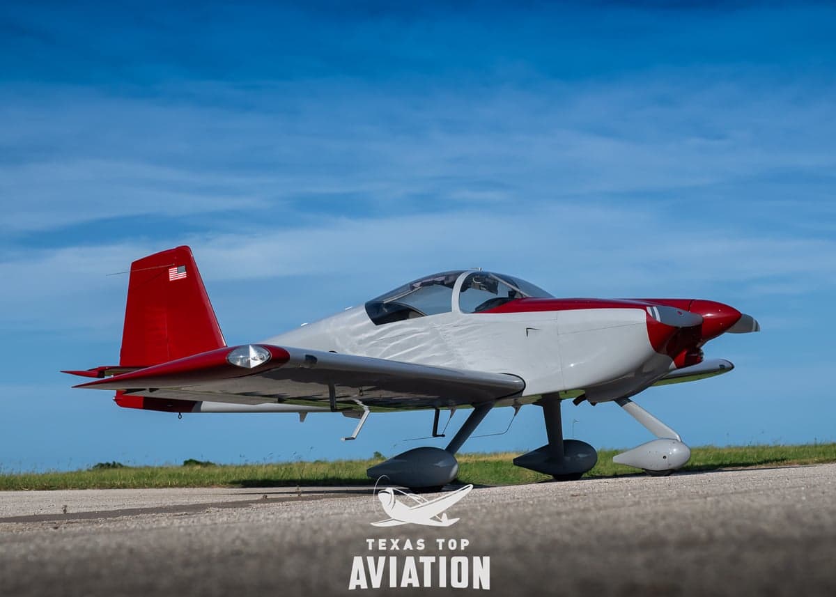 A red and gray aircraft is parked on the tarmac with an American flag on the tail.