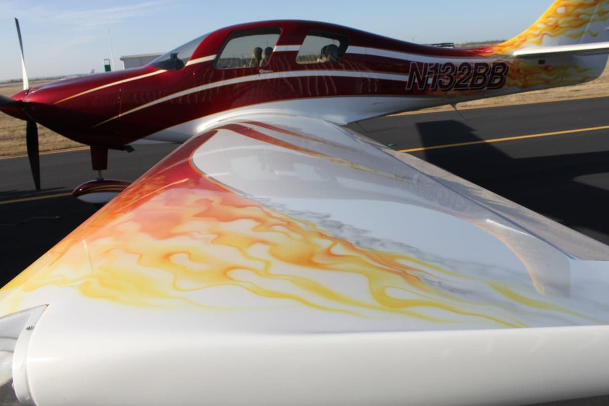 The wing of the aircraft has a flame design and the registration number N132BB is visible on the fuselage.