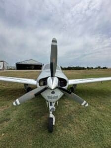 Front view of the Beechcraft Bonanza N333SM on a grassy field.