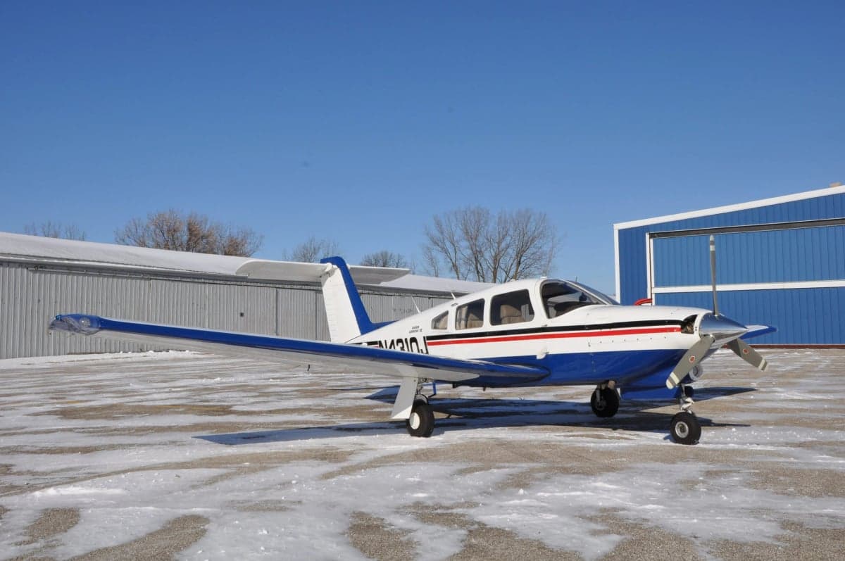 Piper Arrow on a snowy ramp, side view.
