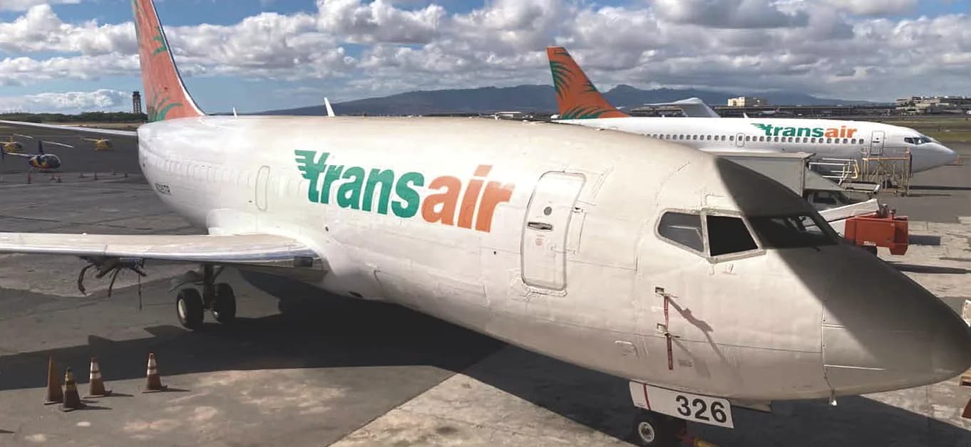 A Transair aircraft is parked on the tarmac.