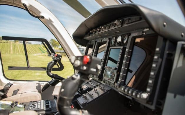A black helicopter sits on the tarmac.