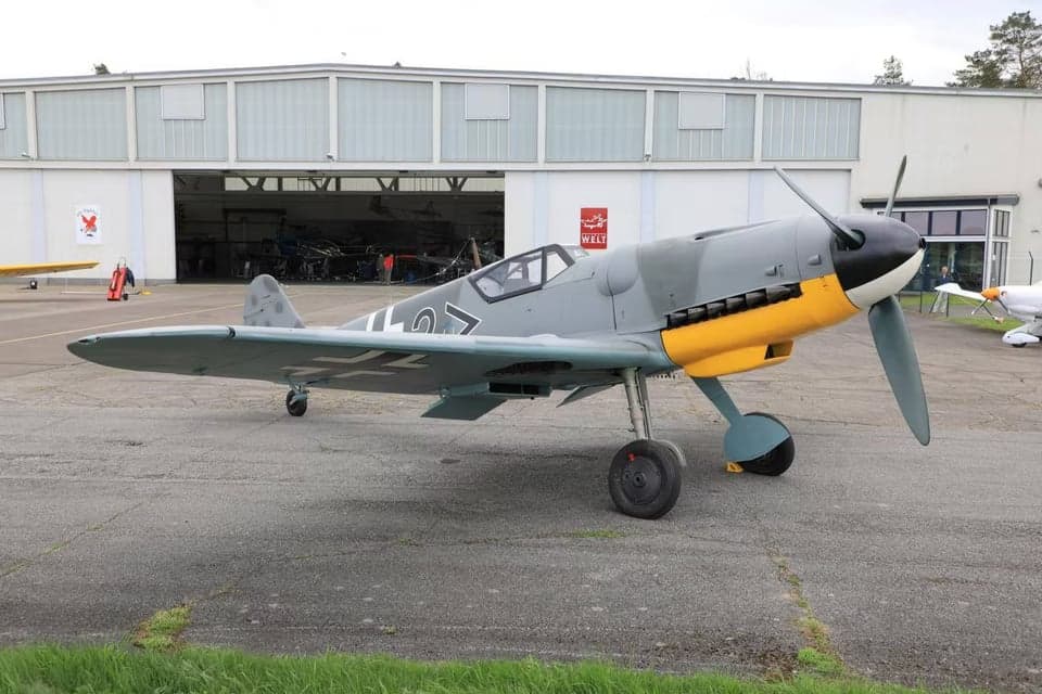 A Messerschmitt Bf 109 parked on the tarmac, side view.