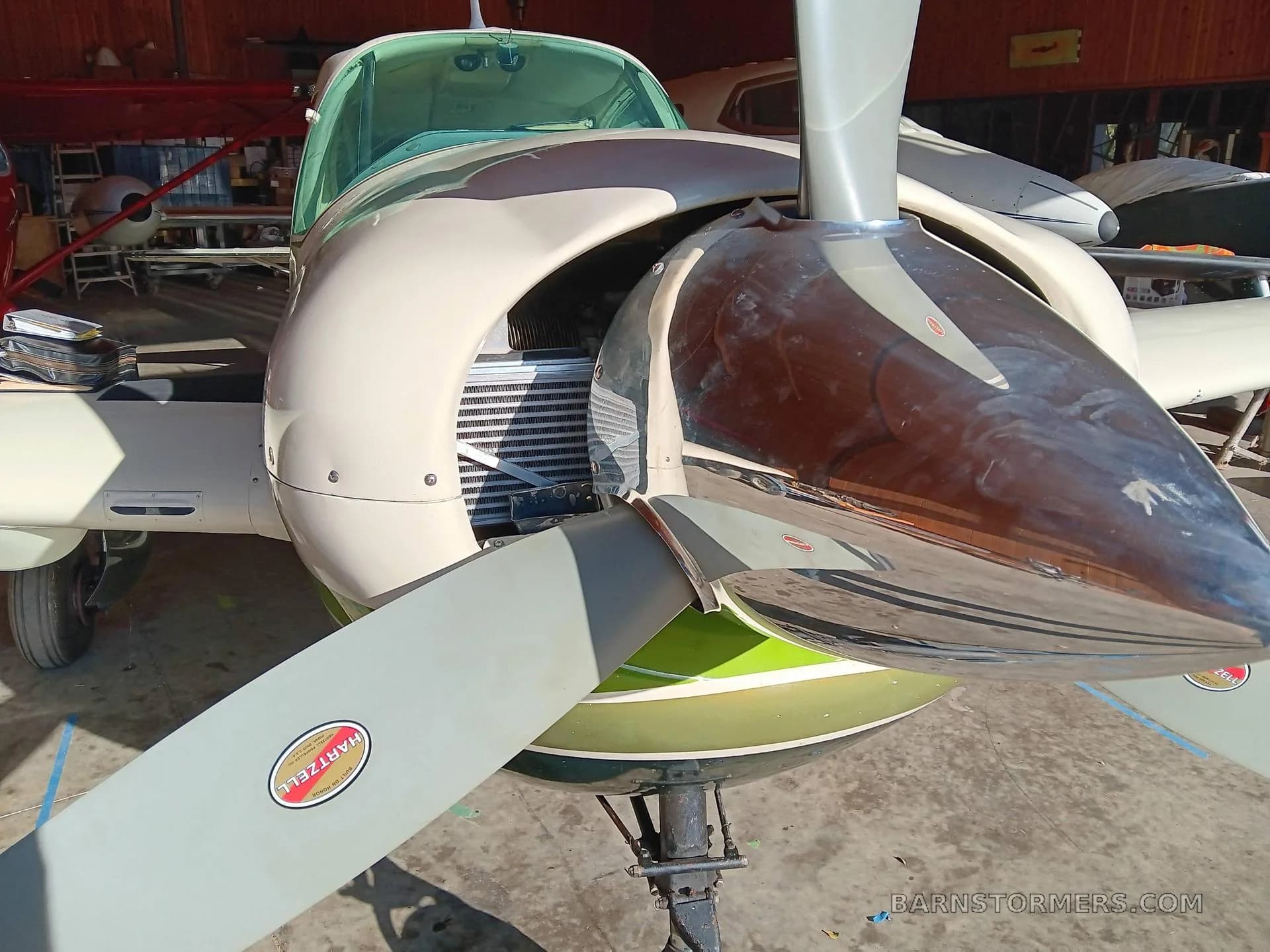 Close-up view of the propeller and nose of a white and green Belanca Super Viking aircraft.