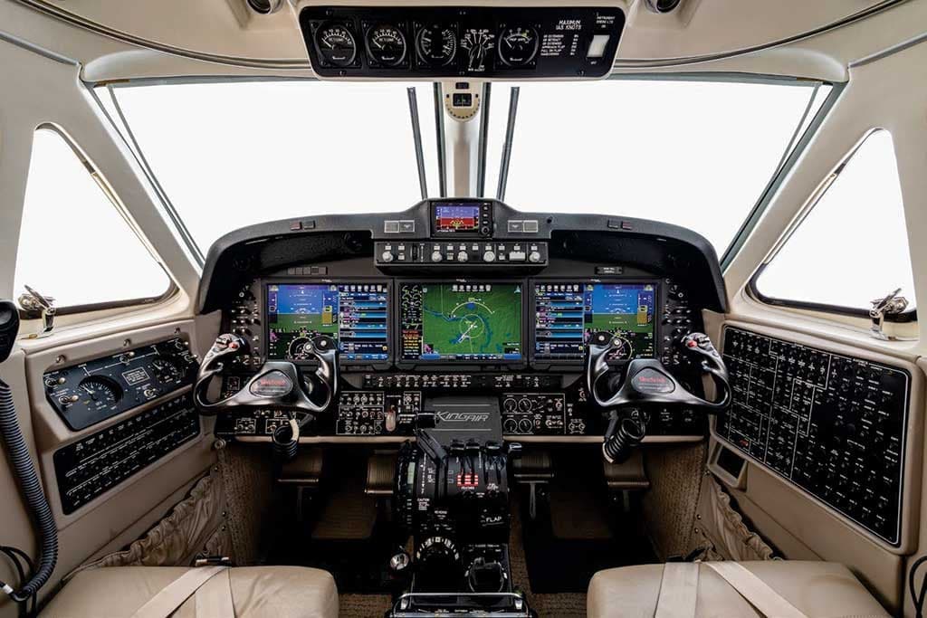 The cockpit of a King Air 360, featuring a modern glass panel display and dual yokes.