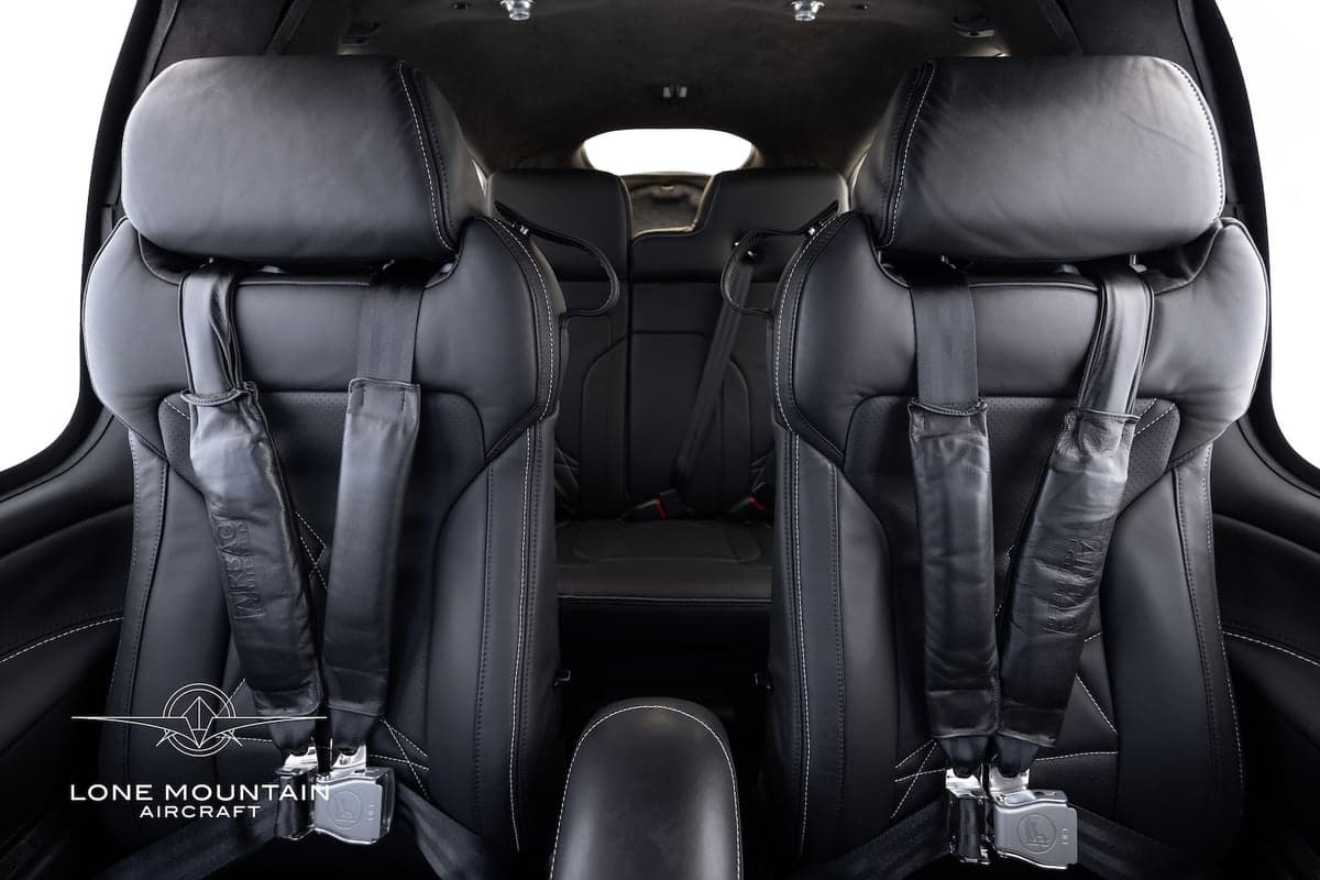 Rear seats of the Cirrus SR22T aircraft, showing the black leather upholstery and seatbelts.
