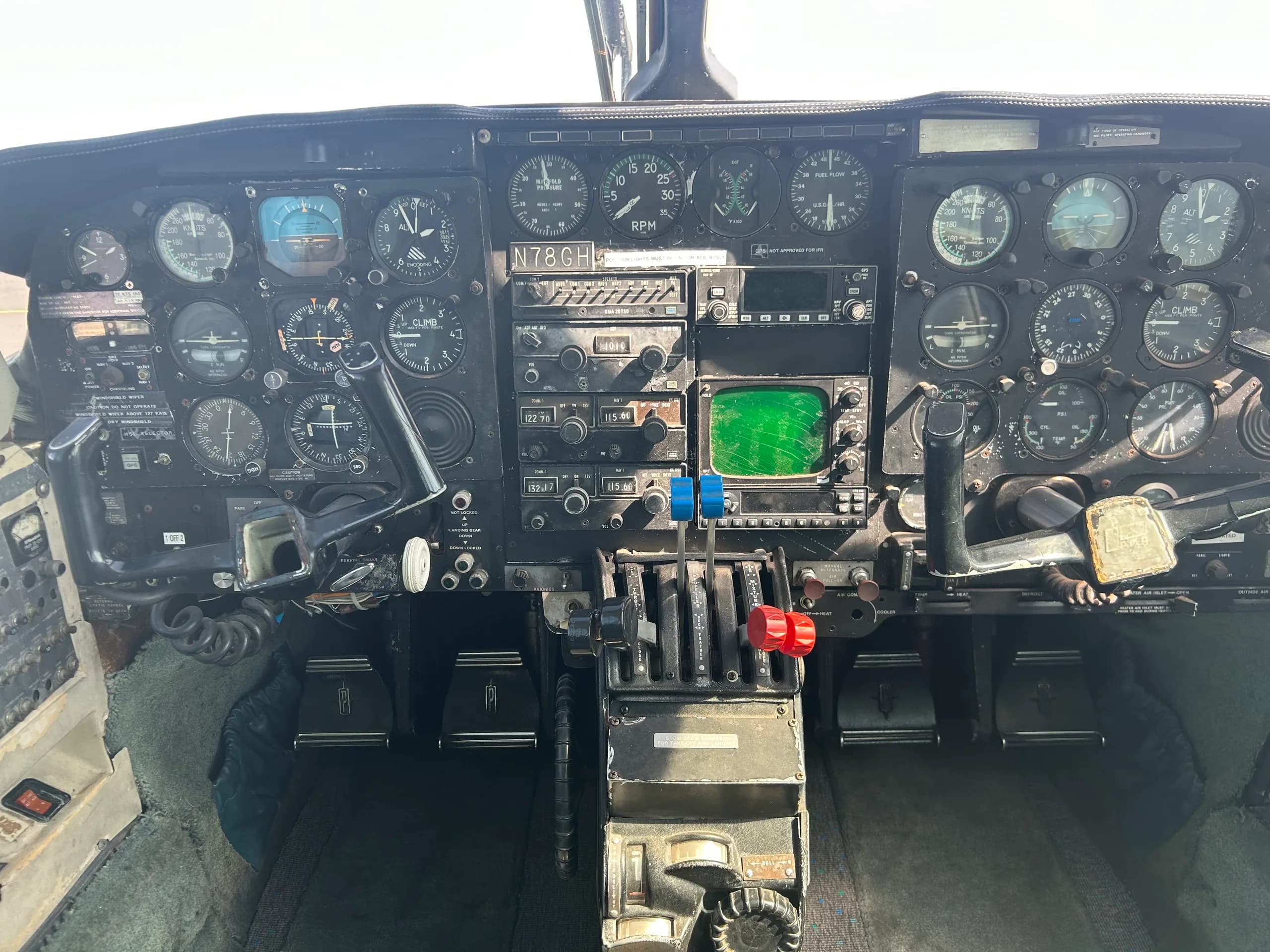 The cockpit instrument panel of aircraft N78GH, showing various gauges, radios, and controls.