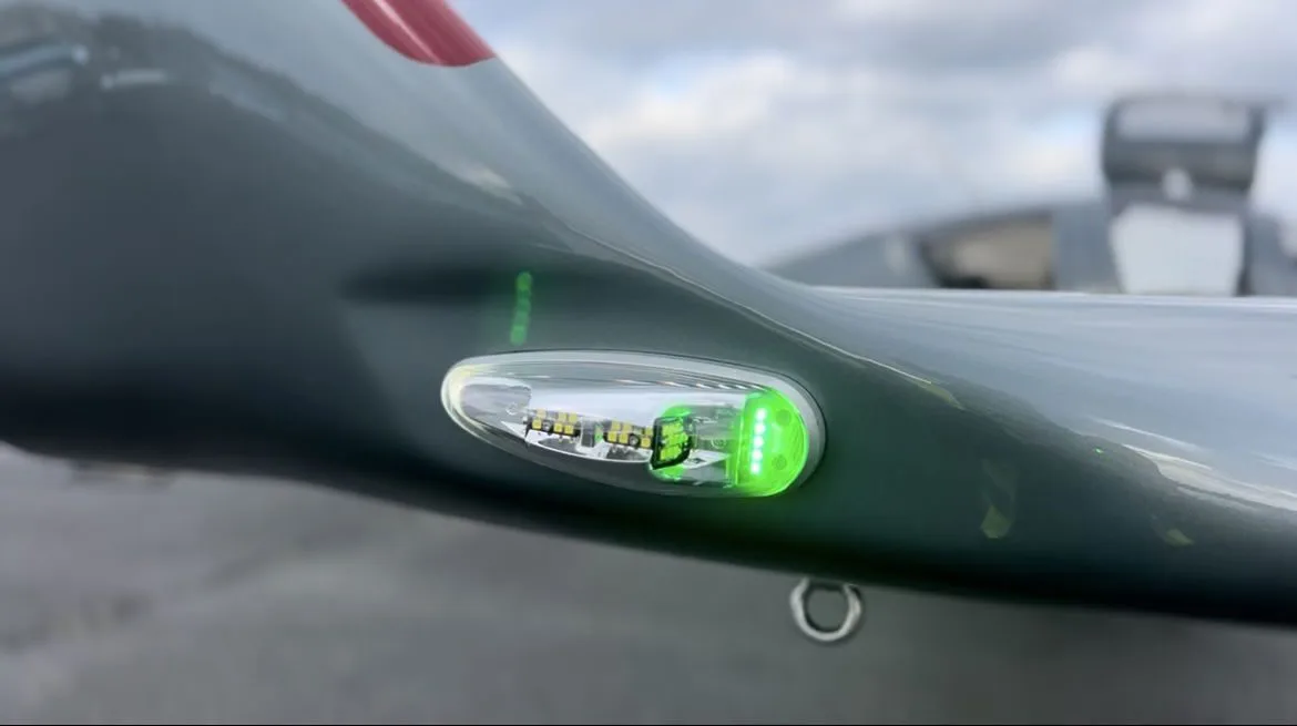 Close-up of the wingtip and navigation light on a gray Diamond DA50 RG aircraft.