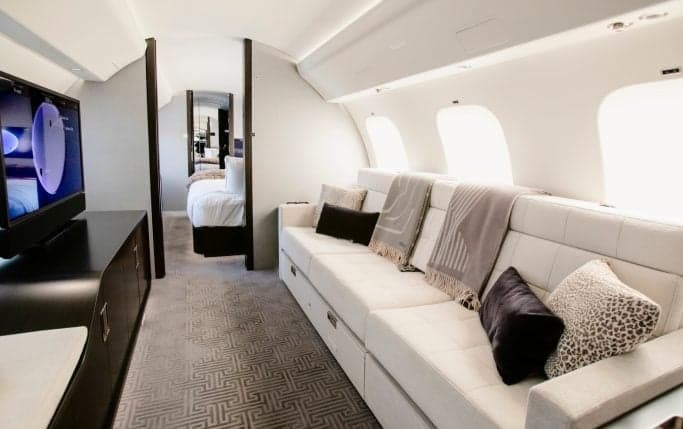 Interior of the Global 7500 cabin with leather seats and a view towards the bedroom area.