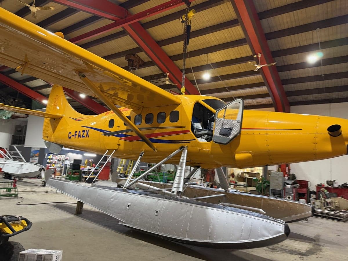 Yellow float plane in a hangar being worked on.