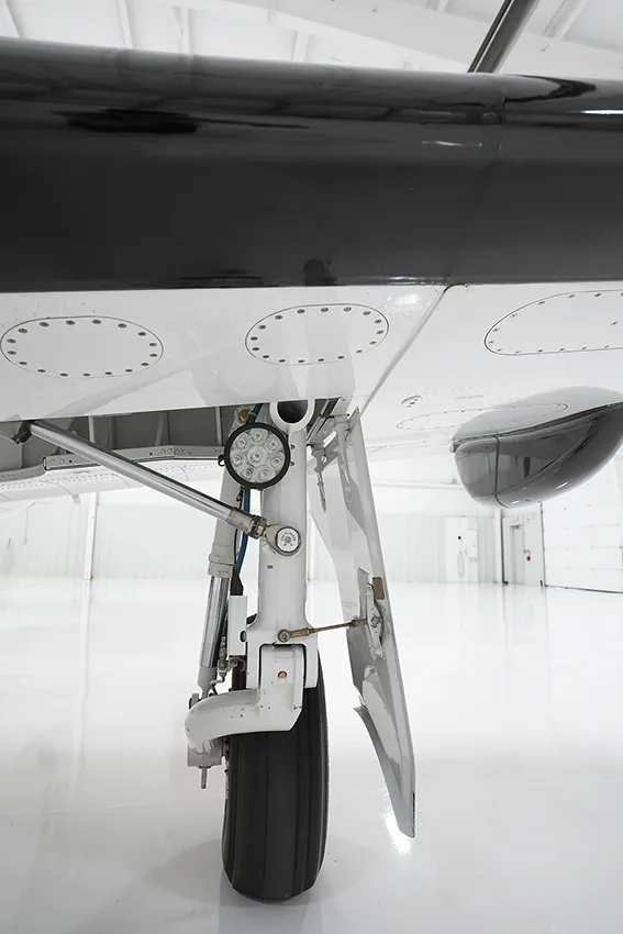 A close-up view of the main landing gear of a Pilatus PC-12 aircraft.