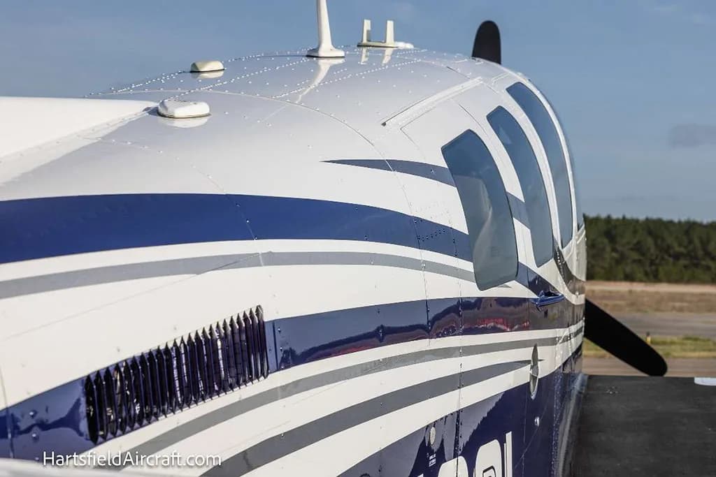 A close-up view of the top of the fuselage and propeller of the blue and white Beechcraft Bonanza N4081.