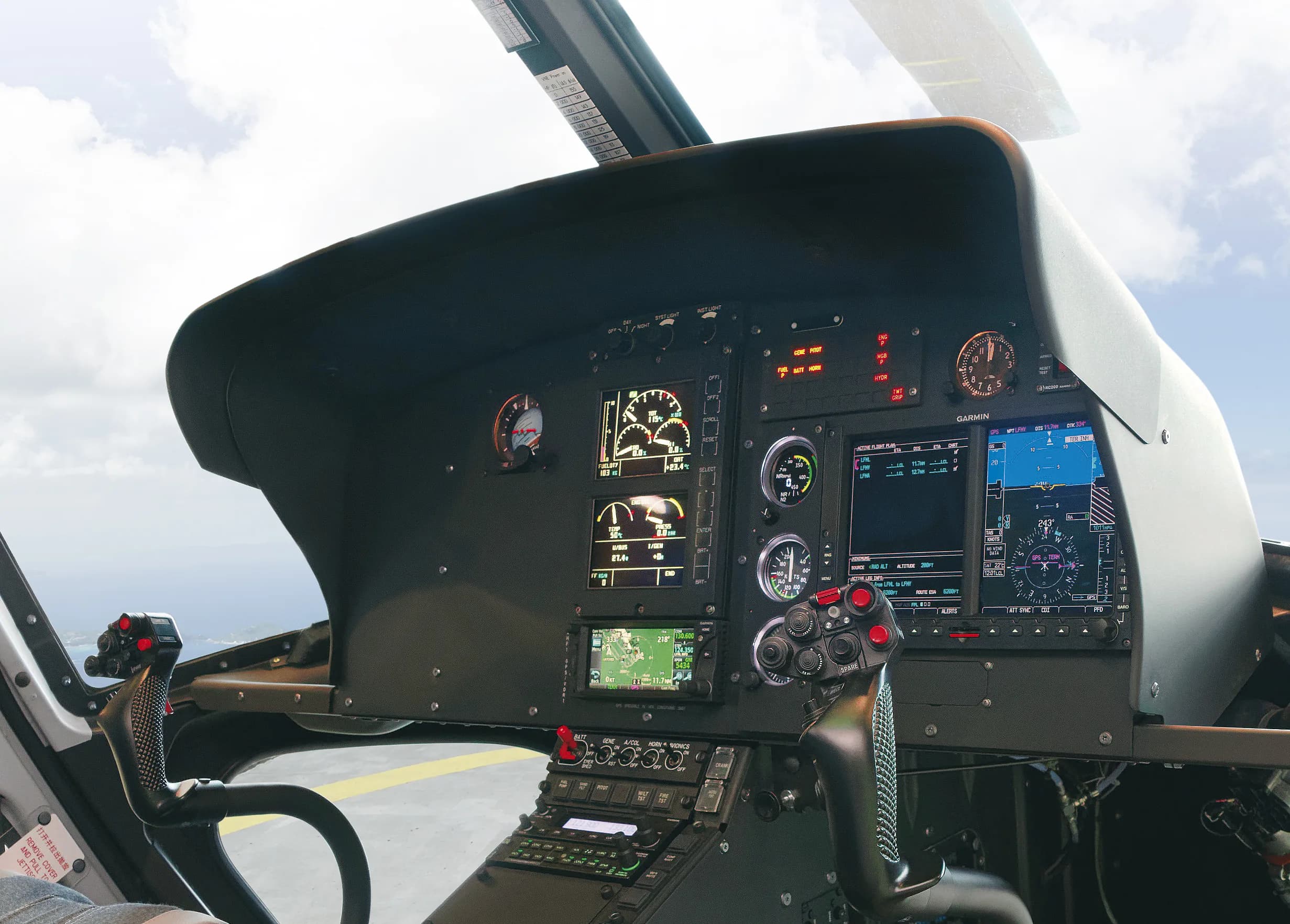 The modern glass cockpit of a helicopter with multiple display screens and controls.