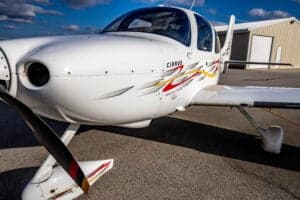 Close-up of the front of a Cirrus SR22 aircraft with a custom paint scheme.