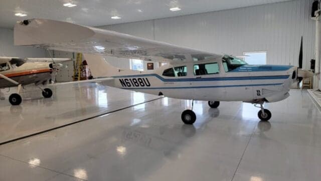 A Cessna Centurion aircraft with a blue and white paint scheme is parked on the tarmac.