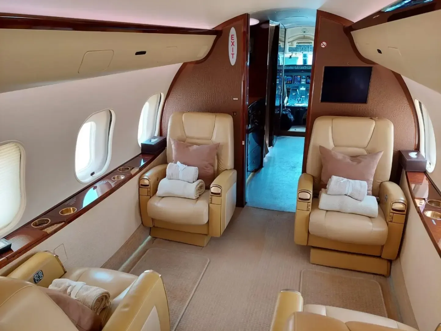The interior of a Bombardier Global Express business jet showing the seating arrangement and amenities.