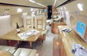 The interior of the aircraft features a dining table and seating area.
