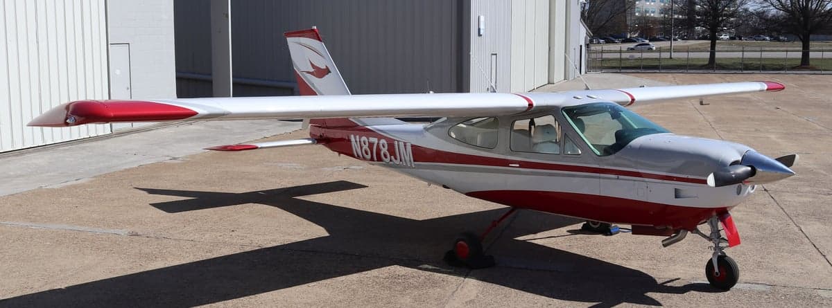 Three-quarter view of the Cessna N878JM parked outside a hangar.