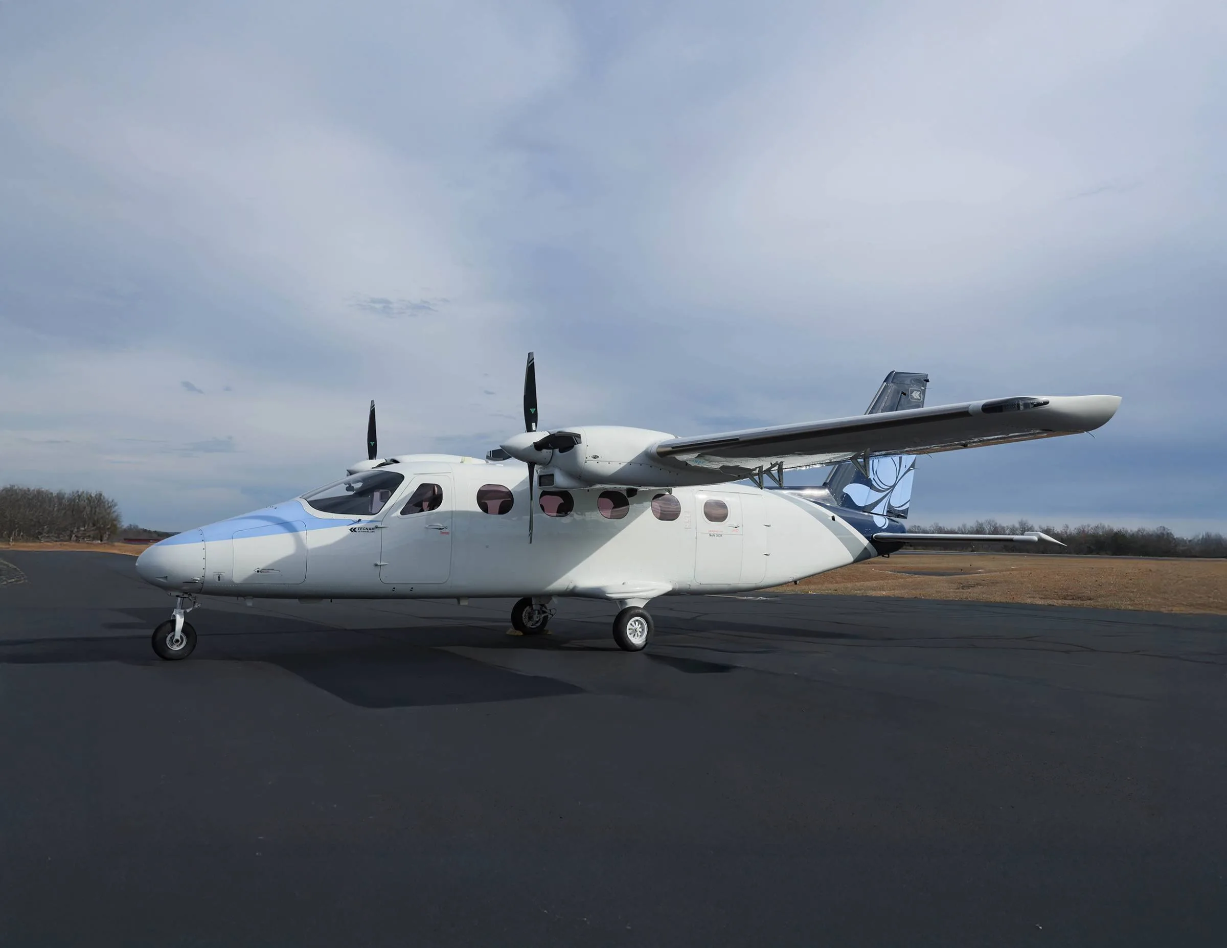 Side view of a white and blue aircraft on the tarmac.