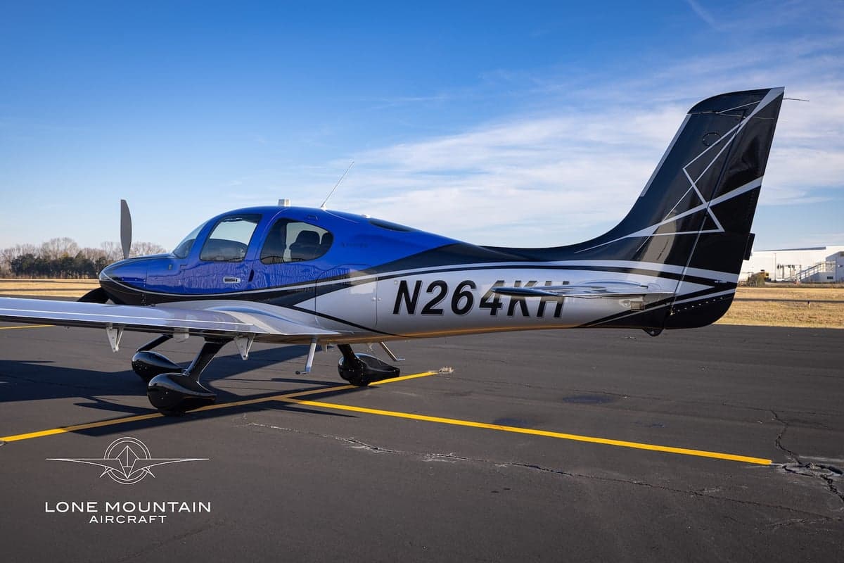 A Cirrus SR22T aircraft with registration N264KH parked on the tarmac, showing the tail design.