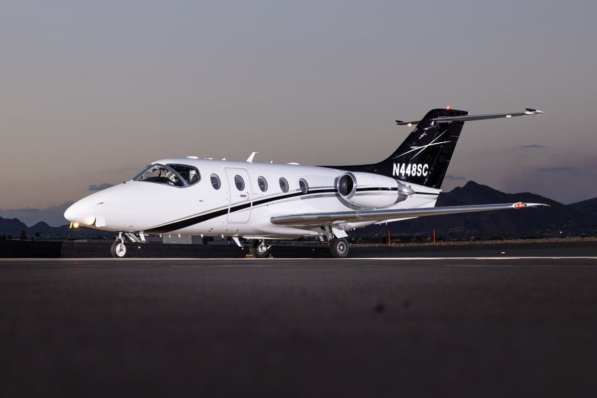 Rear view of the N448SC jet on the tarmac at sunset.
