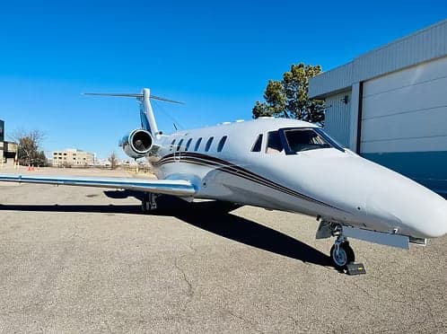 A white Cessna Citation sits on the tarmac.