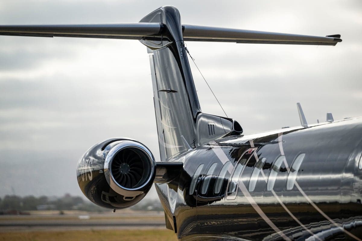Close-up of the tail and engine of a black Pilatus PC-24 jet.