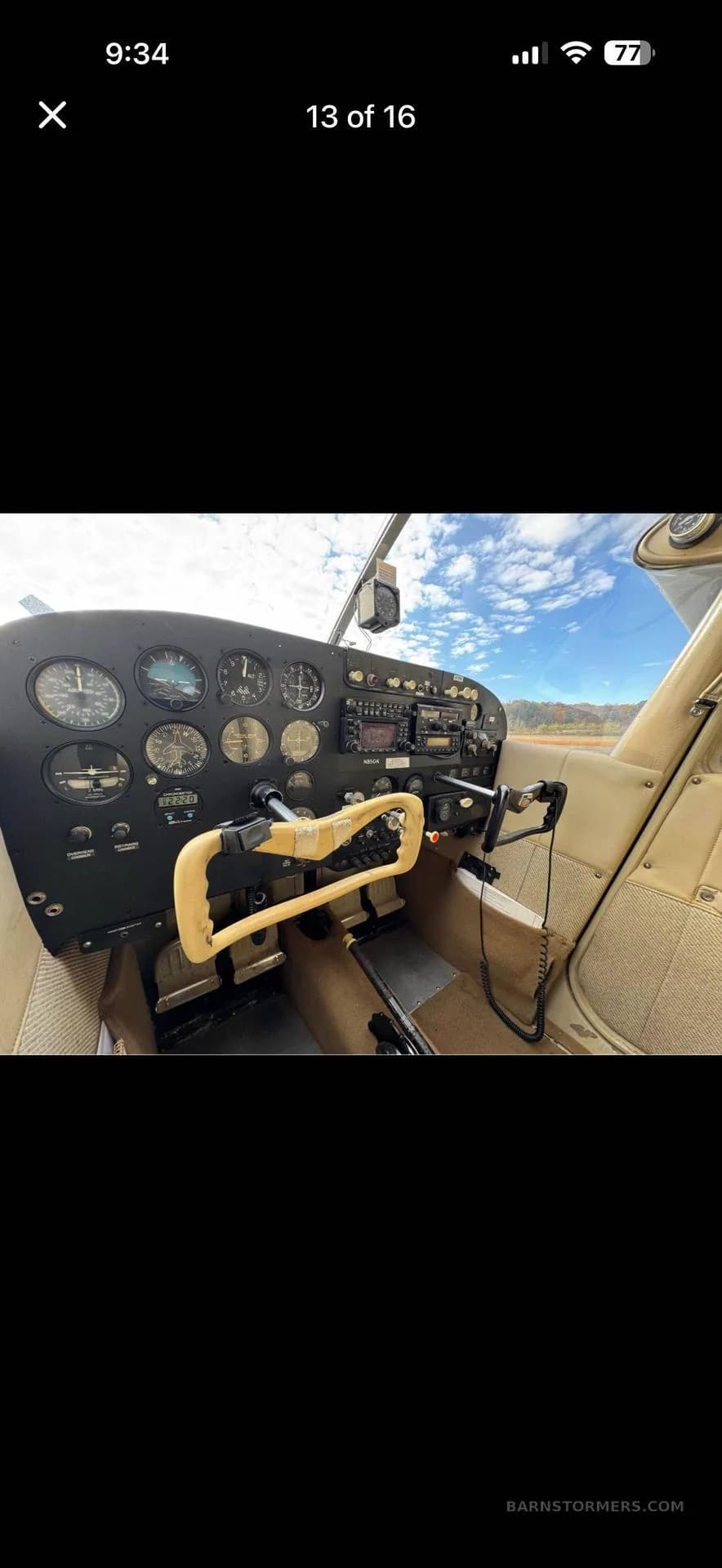 A close-up view of a light aircraft's cockpit, highlighting the instrument panel, control yoke, and beige interior.