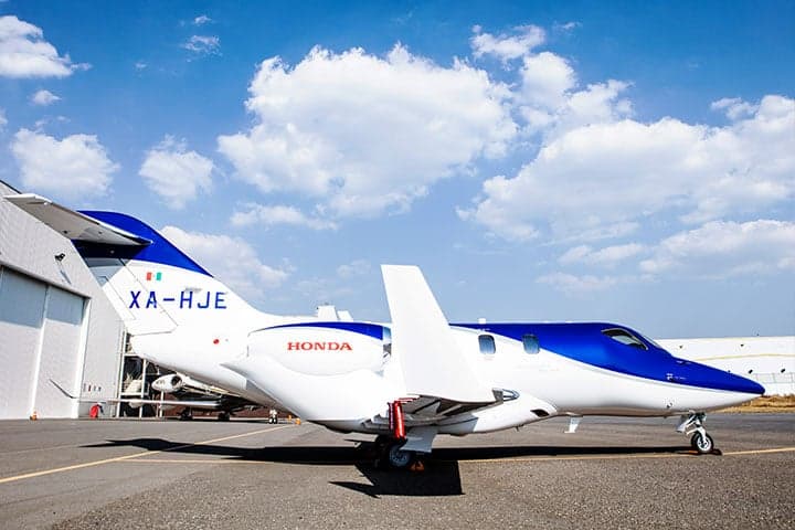 Side view of a HondaJet with registration XA-HJE parked on the tarmac.