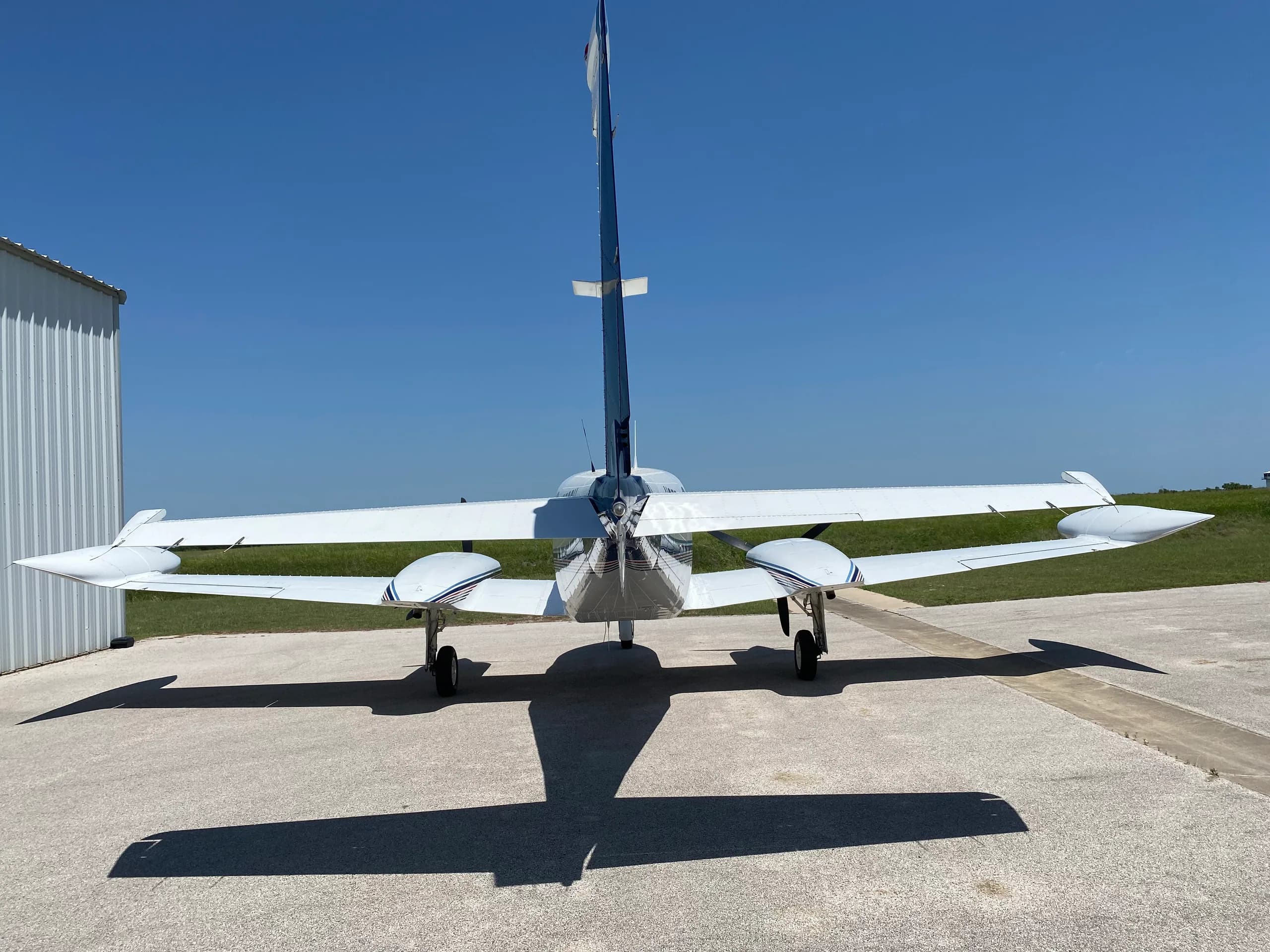 Rear view of a Cessna 340A aircraft with registration N2702V parked on the tarmac.