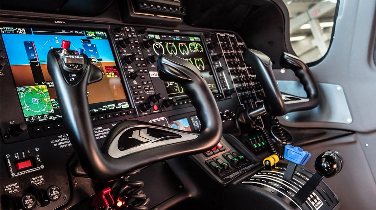 The cockpit of the Tecnam P2006T features a modern glass panel and dual control sticks.