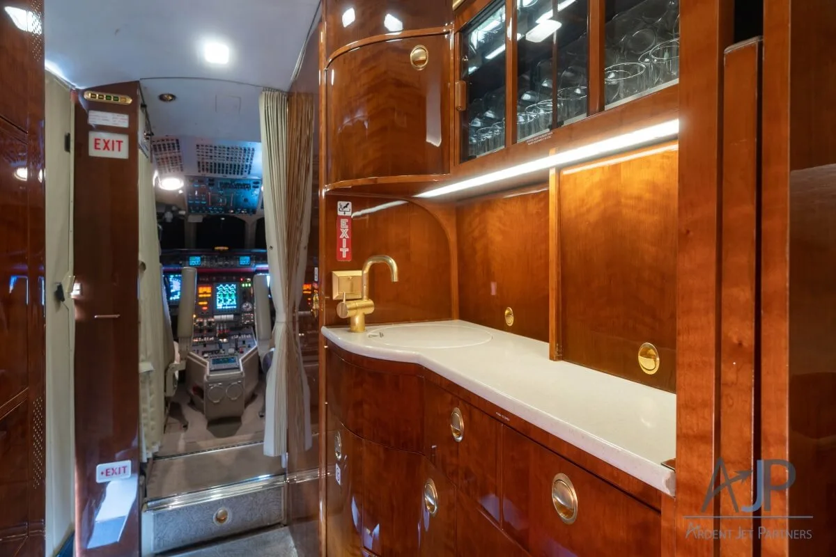 Interior view of the aircraft cabin with couches and wood accents.