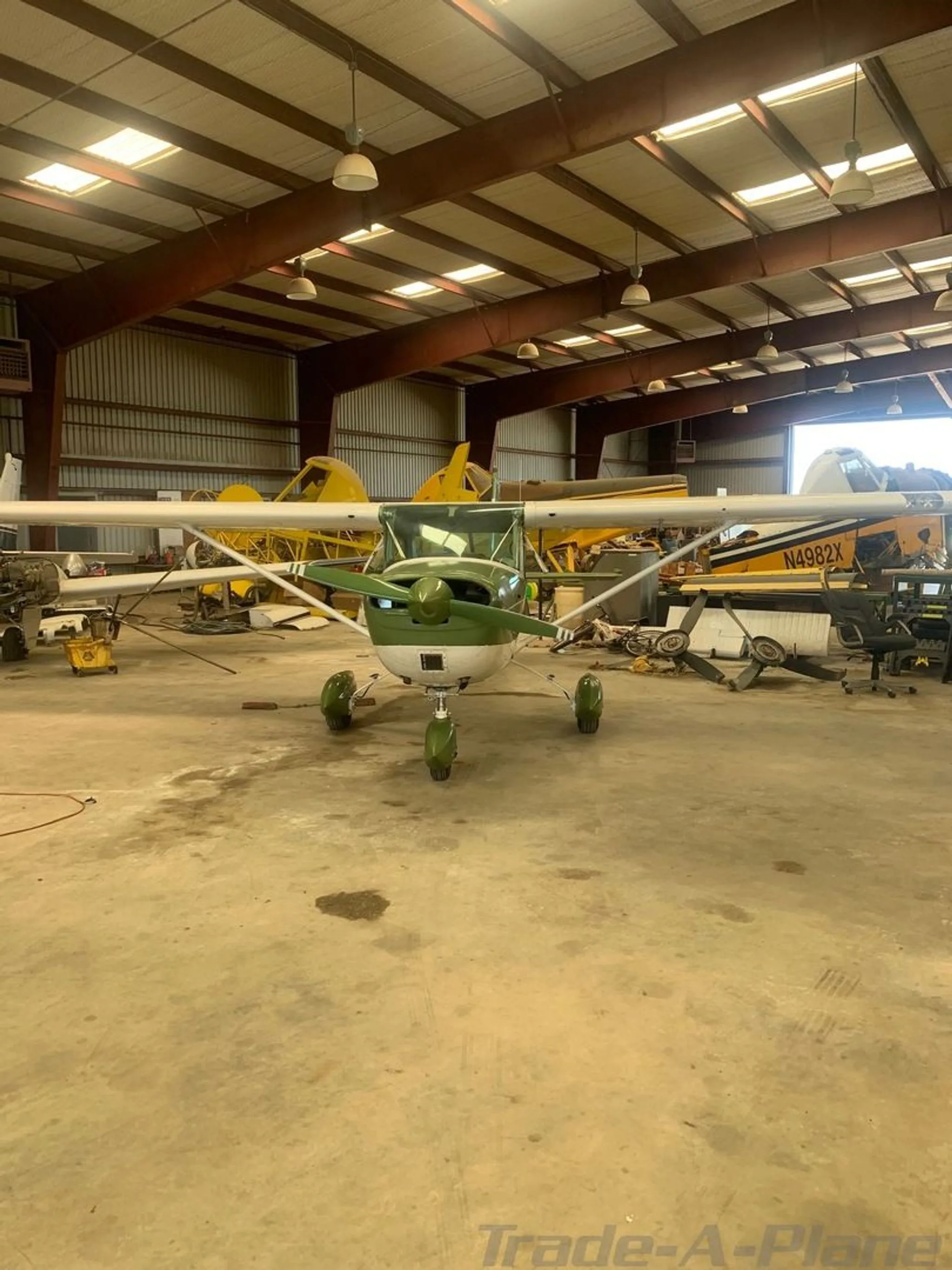 A front view of the green and white Cessna aircraft N50846 parked in a hangar.